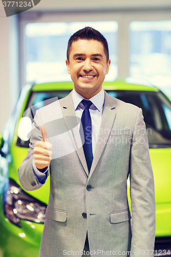 Image of man showing thumbs up at auto show or car salon