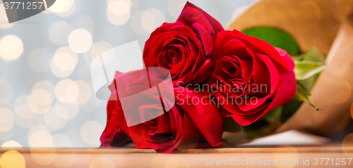 Image of close up of red roses bunch wrapped into paper