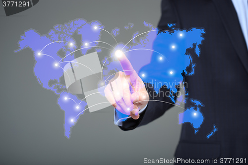 Image of businessman touching a world map on the screen showing global connection between different continents.