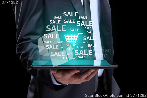 Image of Businessman hand touch online shopping icons on a tablet. sale