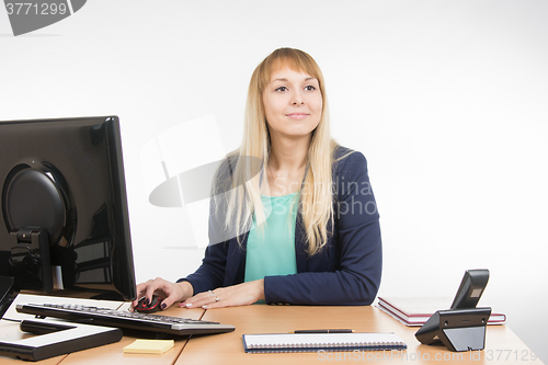 Image of Beautiful girl secretary working at a computer looked at visitor