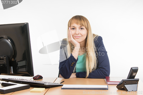 Image of A little bit tired business woman behind a desk