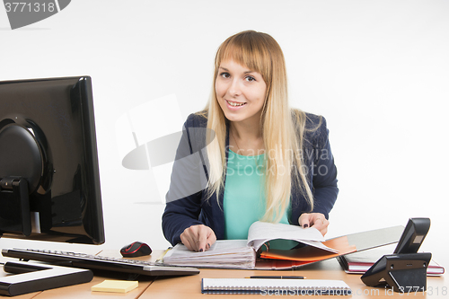 Image of Business woman looks through documents in the folder and looked into the frame