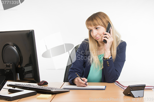 Image of Unhappy business woman answering the phone looking at the screen