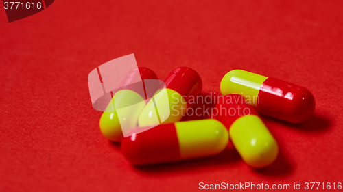 Image of Pills spilling out of pill bottle on red. Top view with copy space. 