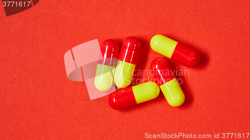 Image of Pills spilling out of pill bottle on red. Top view with copy space. 