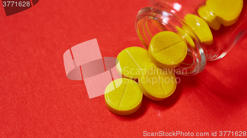 Image of Pills spilling out of pill bottle on red. Top view with copy space. 