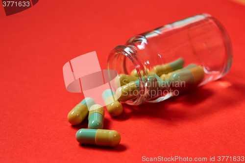 Image of Pills spilling out of pill bottle on red. Top view with copy space. 