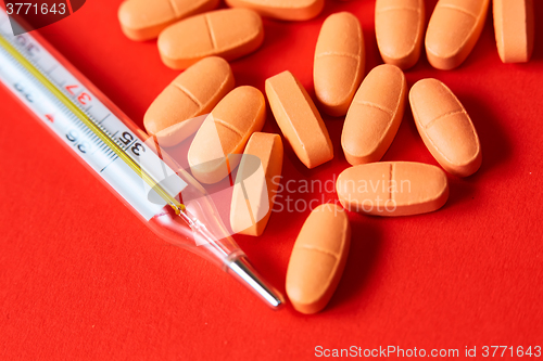 Image of Mercury thermometer and medical pills on background