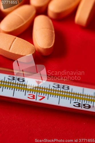 Image of Mercury thermometer and medical pills on background
