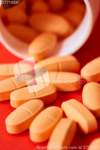 Image of Pills spilling out of pill bottle on red. Top view with copy space. 