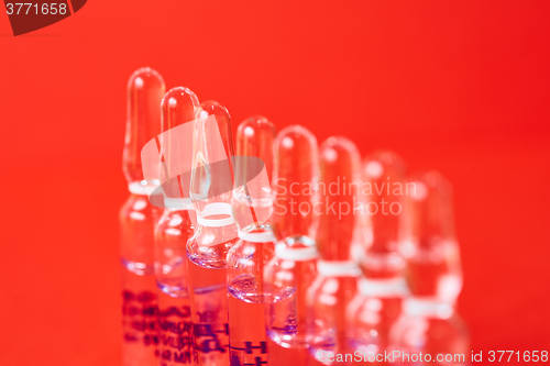 Image of Medical ampules on a red background, selective focus. 