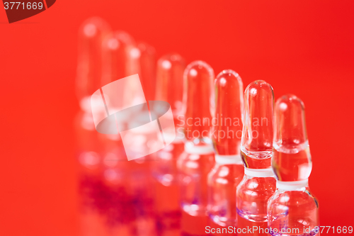 Image of Medical ampules on a red background, selective focus. 