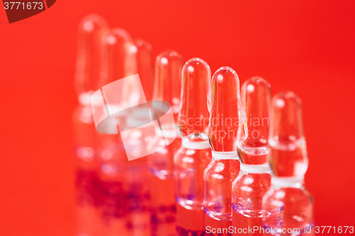 Image of Medical ampules on a red background, selective focus. 