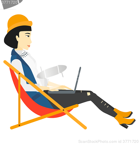 Image of Business woman sitting in chaise lounge with laptop.