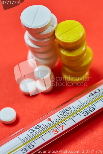 Image of Mercury thermometer and medical pills on background