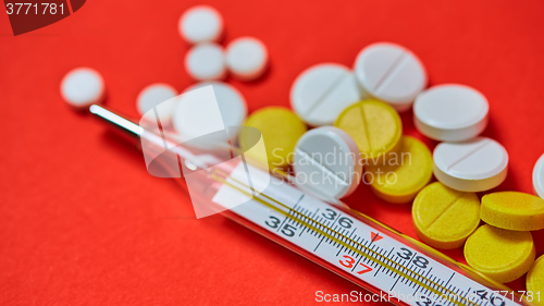 Image of Mercury thermometer and medical pills on background