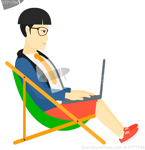 Image of Businessman sitting in chaise lounge with laptop.