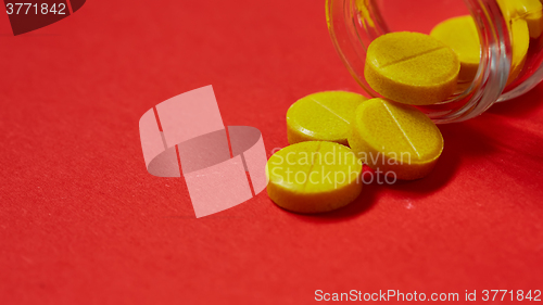 Image of Pills spilling out of pill bottle on red. Top view with copy space. 