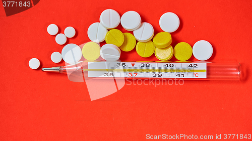 Image of Mercury thermometer and medical pills on background