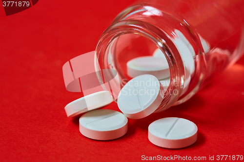 Image of Pills spilling out of pill bottle on red. Top view with copy space. 