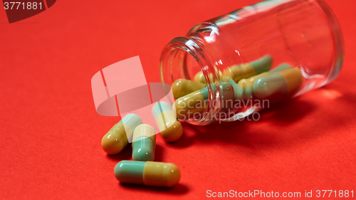 Image of Pills spilling out of pill bottle on red. Top view with copy space. 