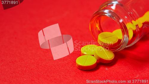 Image of Pills spilling out of pill bottle on red. Top view with copy space. 