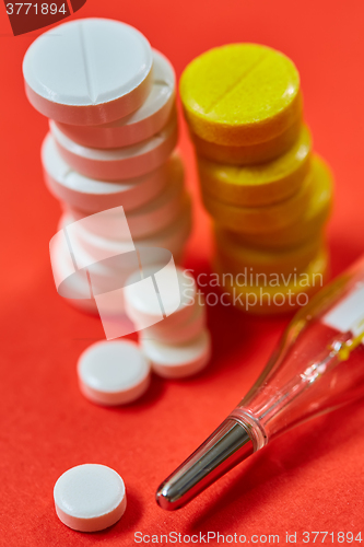 Image of Mercury thermometer and medical pills on background