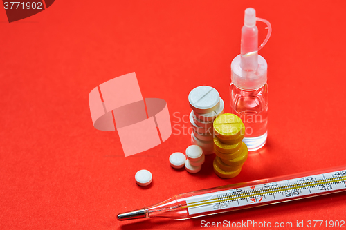 Image of Mercury thermometer and medical pills on background