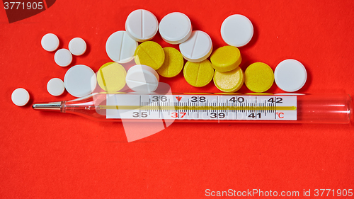 Image of Mercury thermometer and medical pills on background