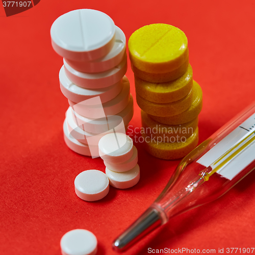 Image of Mercury thermometer and medical pills on background
