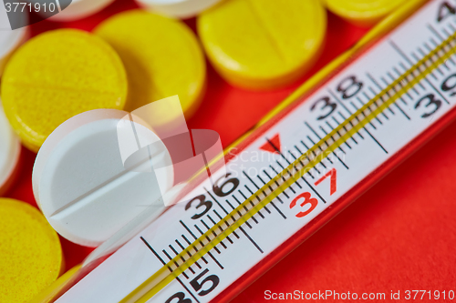 Image of Mercury thermometer and medical pills on background