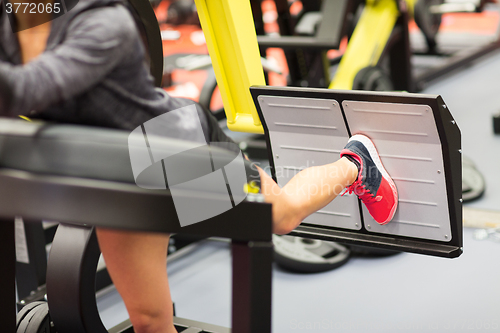 Image of woman flexing muscles on leg press machine in gym