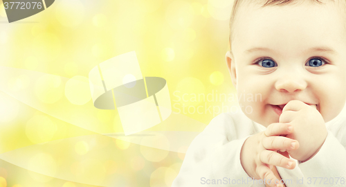 Image of close up of happy baby over yellow background