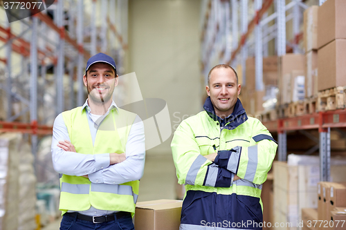 Image of men in uniform with boxes at warehouse