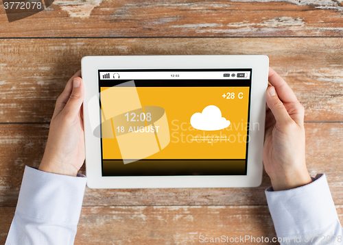 Image of close up of hands with weather cast on tablet pc