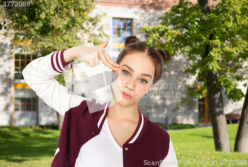 Image of bored teenage girl making finger gun gesture