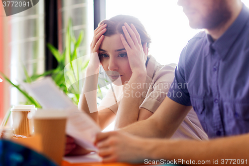 Image of creative team with reading paper in office