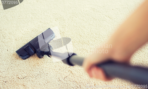 Image of close up of hand with vacuum cleaner at home