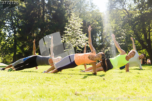 Image of group of happy friends exercising outdoors