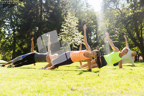 Image of group of happy friends exercising outdoors