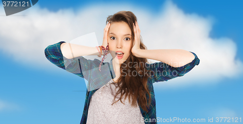 Image of happy pretty teenage girl holding to head