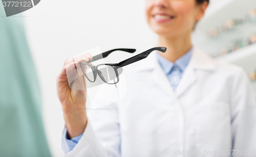 Image of close up of optician with glasses at optics store