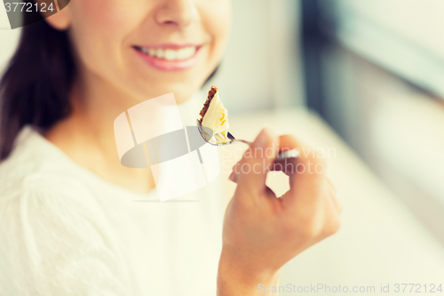 Image of close up of woman eating cake at cafe or home