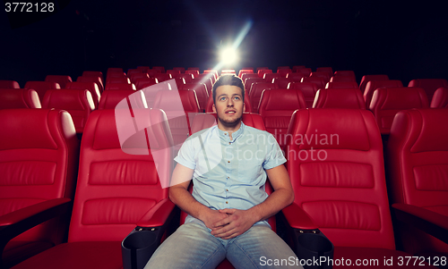 Image of happy young man watching movie in theater