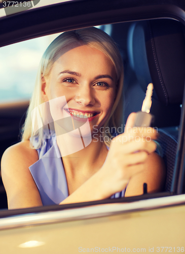 Image of happy woman getting car key in auto show or salon