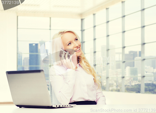 Image of smiling businesswoman calling on smartphone