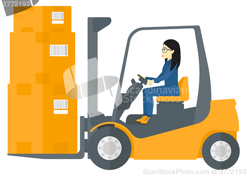 Image of Worker moving load by forklift truck.