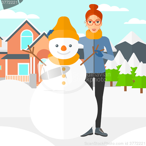 Image of Woman posing near snowman.