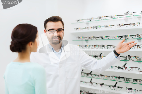 Image of woman and optician showing glasses at optics store